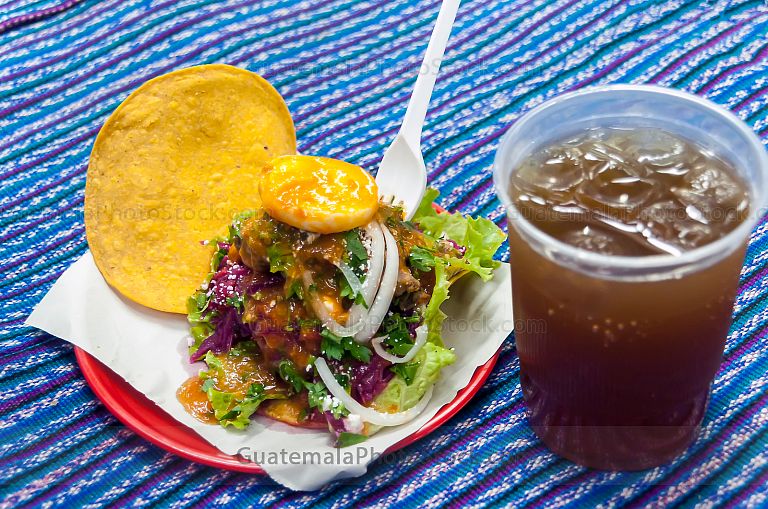 Enchilada servida con agua de tamarindo