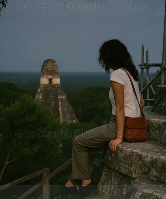 Mujer contemplando el amanecer desde las ruinas mayas en Tikal